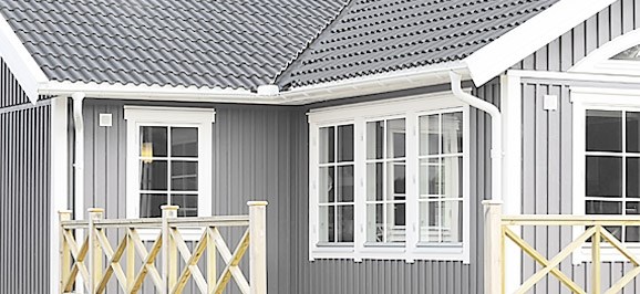 Gråmalet træhus med hvide vinduer